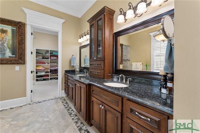 full bathroom with double vanity, crown molding, baseboards, and a sink