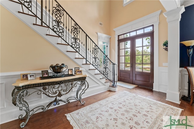 foyer with ornate columns, french doors, and wood-type flooring