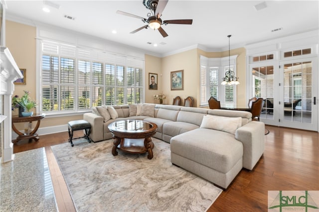 living room featuring crown molding, ceiling fan with notable chandelier, and hardwood / wood-style floors