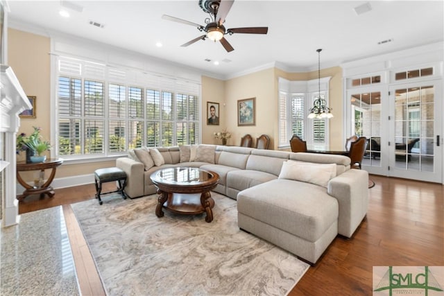 living room featuring visible vents, baseboards, recessed lighting, crown molding, and ceiling fan with notable chandelier