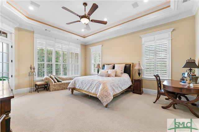 carpeted bedroom with ceiling fan, a raised ceiling, and ornamental molding