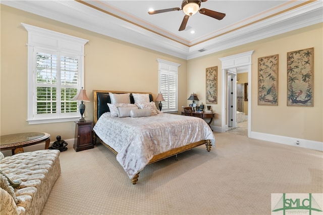 carpeted bedroom with ceiling fan, ensuite bath, crown molding, and a tray ceiling