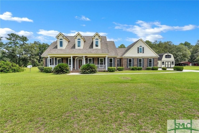 cape cod home featuring covered porch and a front yard