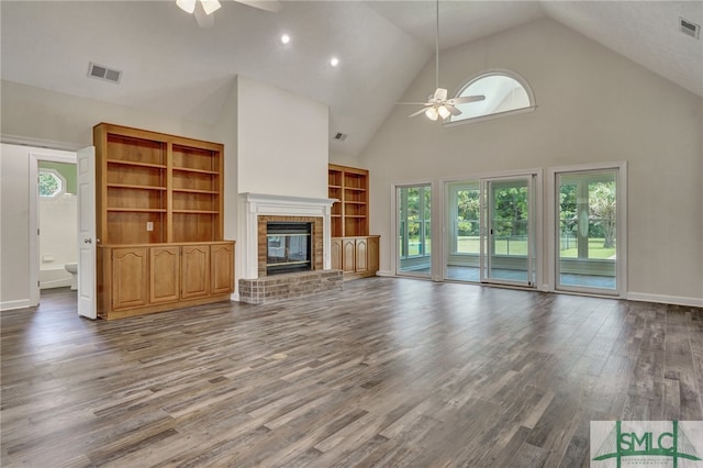 unfurnished living room with ceiling fan, high vaulted ceiling, a fireplace, and hardwood / wood-style flooring