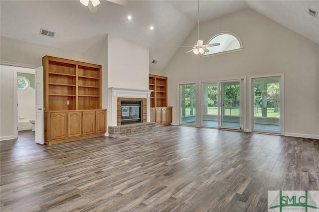 unfurnished living room with ceiling fan, wood-type flooring, high vaulted ceiling, and a brick fireplace