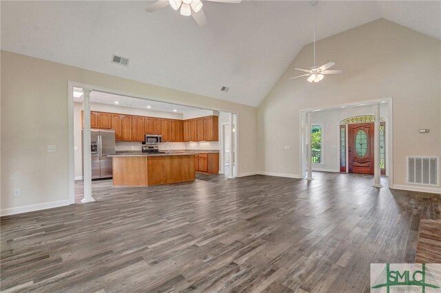 unfurnished living room featuring high vaulted ceiling, wood-type flooring, ornate columns, and ceiling fan