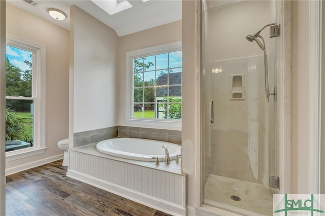 bathroom featuring a wealth of natural light, toilet, hardwood / wood-style floors, and independent shower and bath