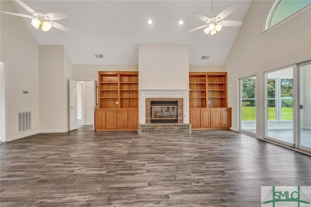 unfurnished living room with a brick fireplace, dark hardwood / wood-style floors, and ceiling fan