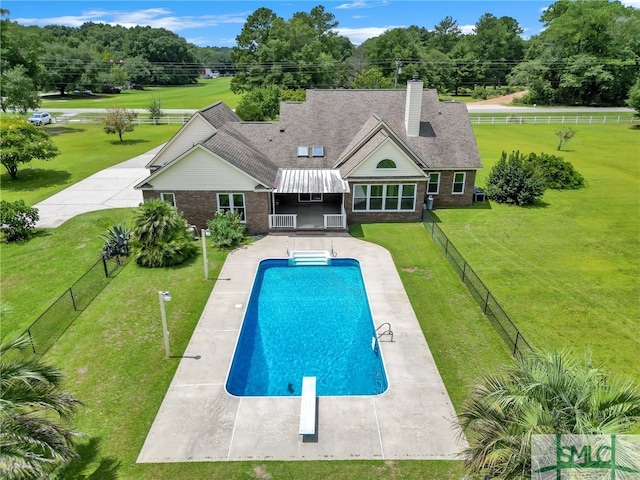 view of swimming pool with a lawn, a patio, and a diving board