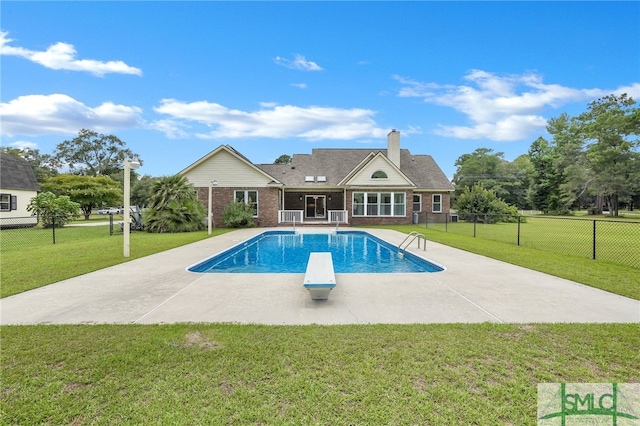 view of pool featuring a patio, a diving board, and a yard