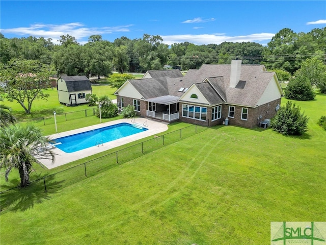 view of swimming pool with a storage shed, a yard, a patio area, and cooling unit