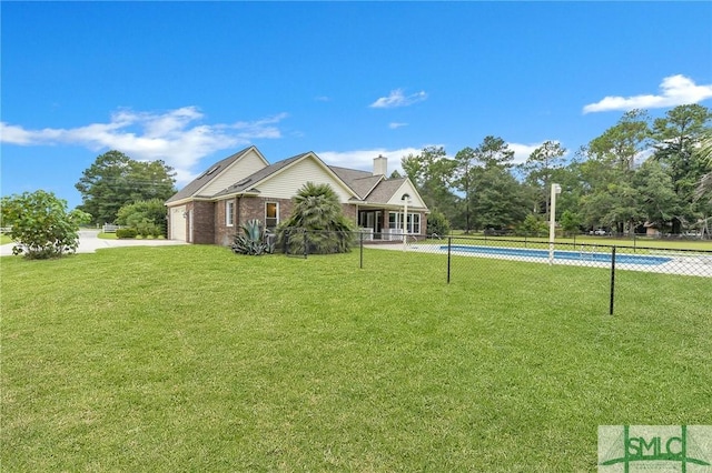 view of front of home with a fenced in pool and a front lawn