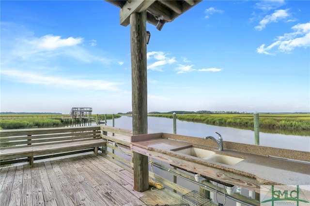 deck featuring sink, a water view, and a boat dock