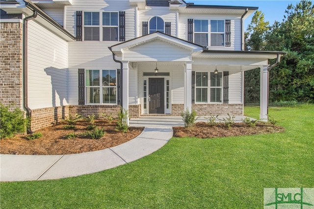 view of front facade with a front yard and covered porch