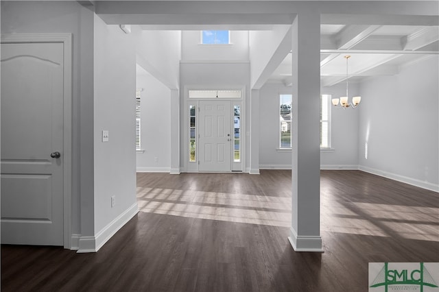 entrance foyer with a notable chandelier, beamed ceiling, coffered ceiling, and dark hardwood / wood-style flooring