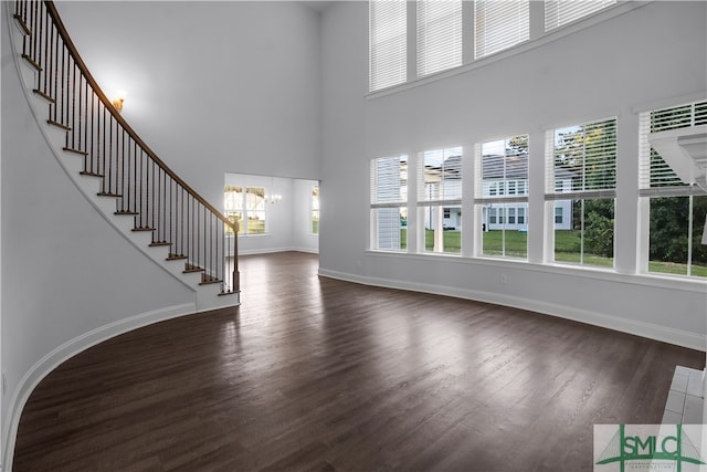 entrance foyer with a towering ceiling and dark hardwood / wood-style floors