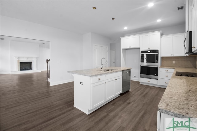 kitchen featuring stainless steel appliances, white cabinetry, a kitchen island with sink, and sink