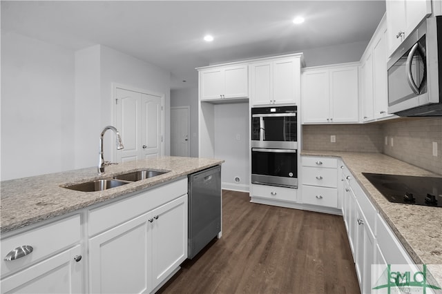 kitchen featuring light stone counters, sink, white cabinets, stainless steel appliances, and dark hardwood / wood-style flooring