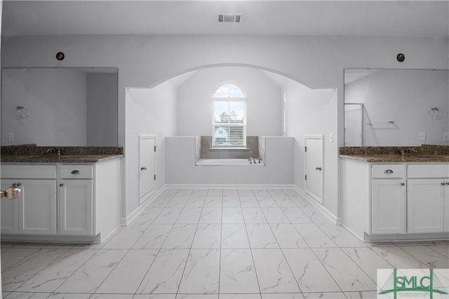 interior space with white cabinets, dark stone countertops, and sink