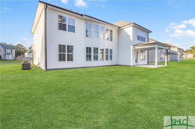 back of property with a yard, a patio, and central AC