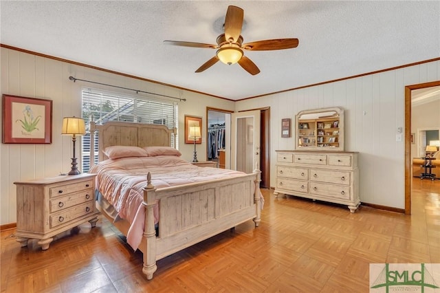 bedroom featuring light parquet flooring, ceiling fan, a spacious closet, a textured ceiling, and a closet