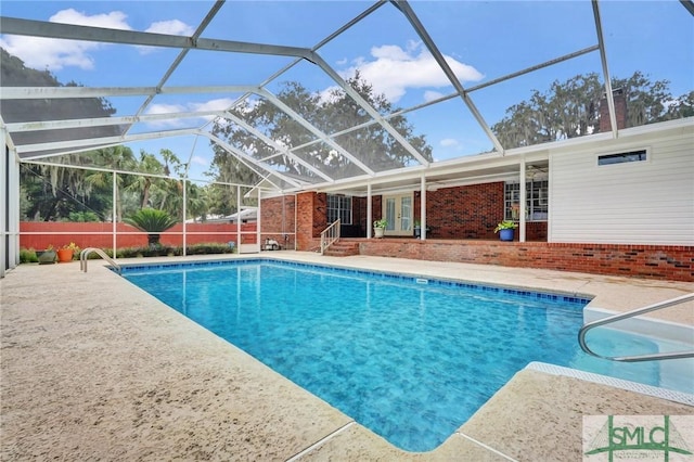 view of pool with glass enclosure and a patio area