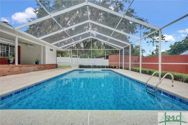 view of pool featuring glass enclosure, ceiling fan, and a patio