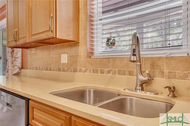 kitchen with dishwasher, decorative backsplash, light brown cabinetry, and sink