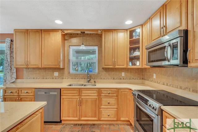 kitchen with light brown cabinets, backsplash, sink, decorative light fixtures, and stainless steel appliances