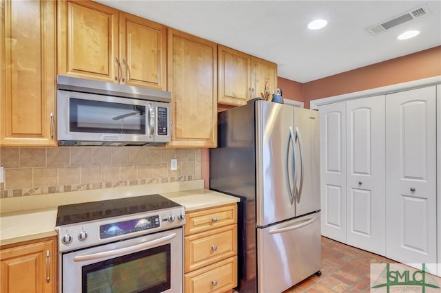 kitchen with appliances with stainless steel finishes and tasteful backsplash