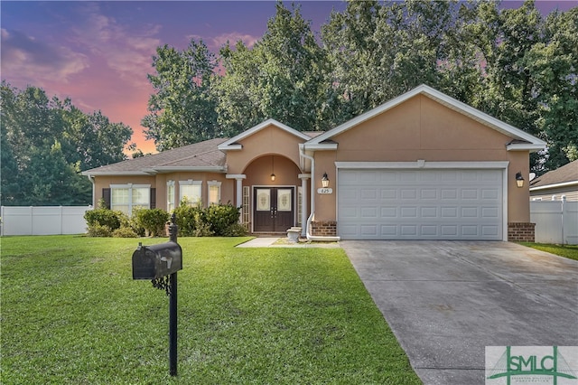 ranch-style house featuring a garage and a lawn