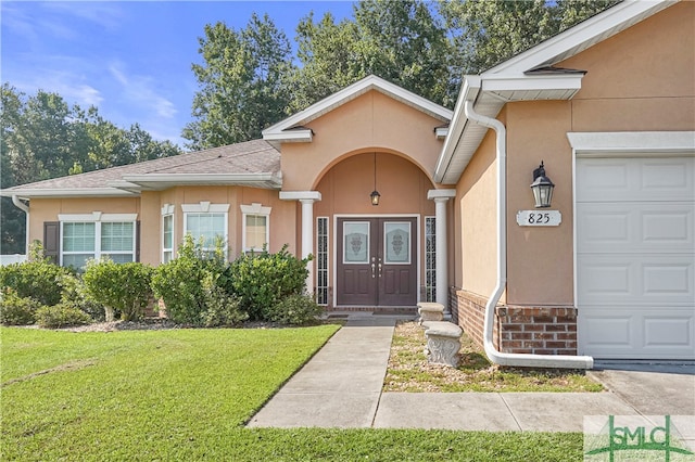 property entrance with a garage and a yard