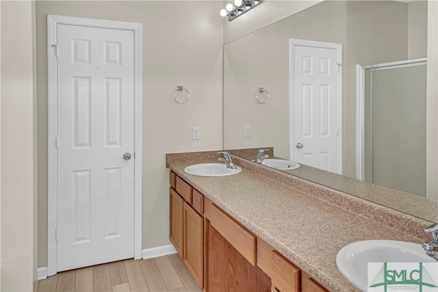 bathroom with dual vanity and hardwood / wood-style floors