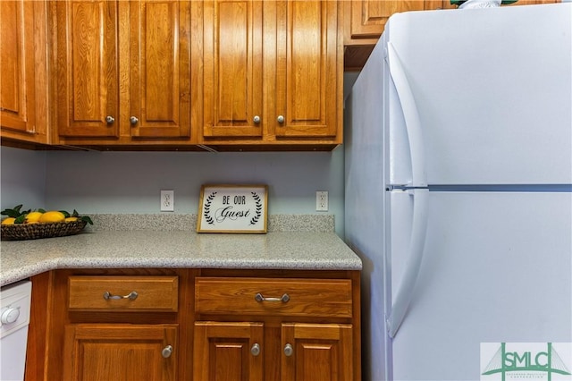 kitchen featuring light countertops, white appliances, and brown cabinets