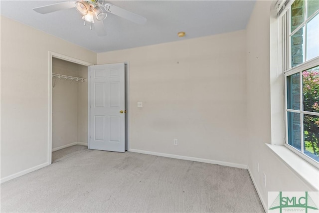 unfurnished bedroom featuring a closet, light colored carpet, ceiling fan, and baseboards