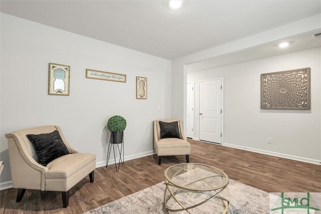 living area featuring baseboards and dark wood-type flooring