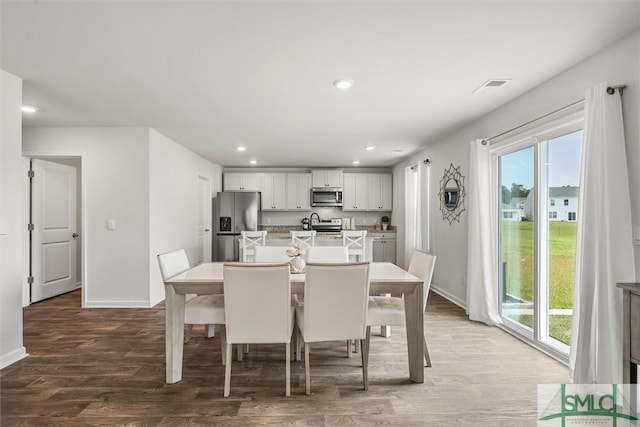 dining space with visible vents, baseboards, wood finished floors, and recessed lighting