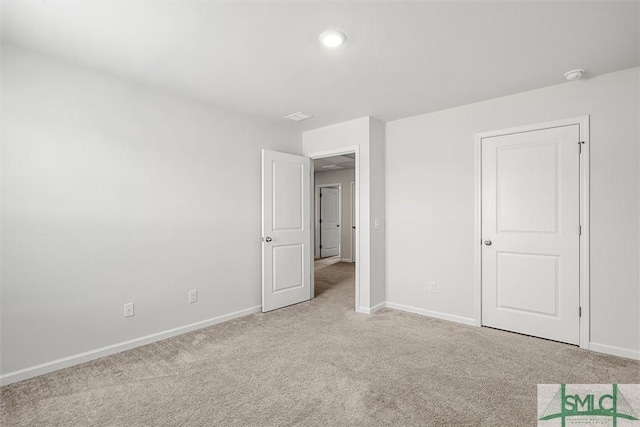 unfurnished bedroom featuring light carpet and baseboards