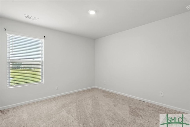 spare room with light carpet, baseboards, and visible vents