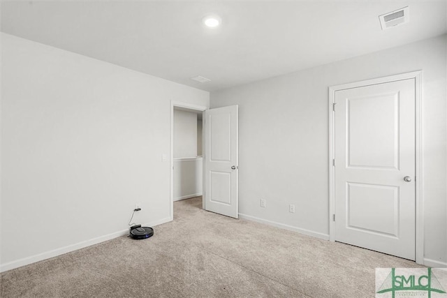 unfurnished bedroom with light carpet, baseboards, and visible vents