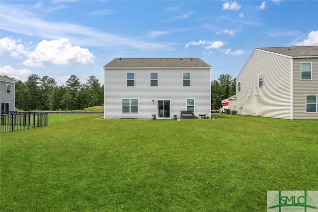 back of house with fence and a yard