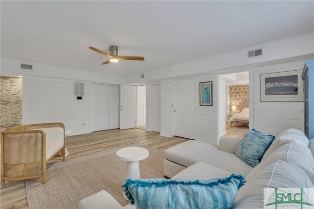 living room featuring light hardwood / wood-style flooring and ceiling fan