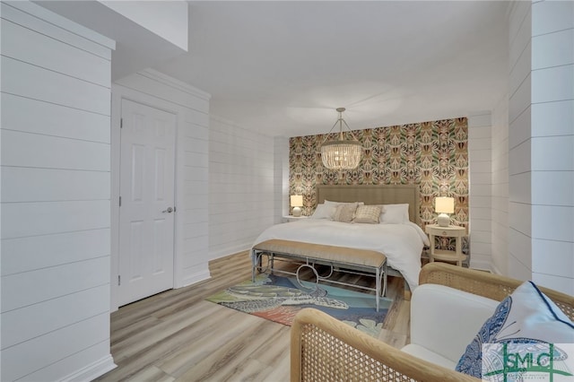 bedroom with a notable chandelier and light hardwood / wood-style flooring