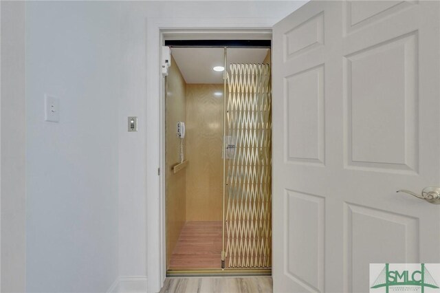 interior space featuring elevator and light hardwood / wood-style floors