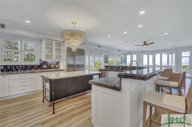 kitchen featuring a center island, pendant lighting, a healthy amount of sunlight, and built in refrigerator