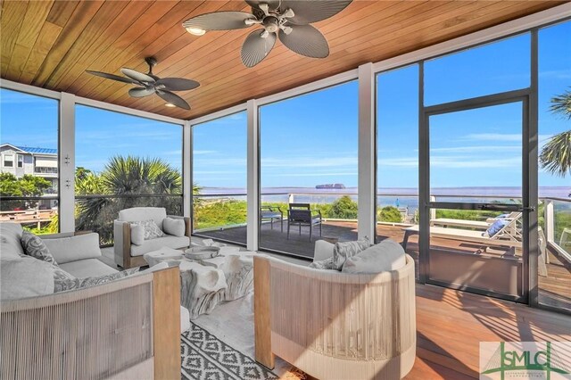 sunroom / solarium featuring wood ceiling, ceiling fan, and a water view