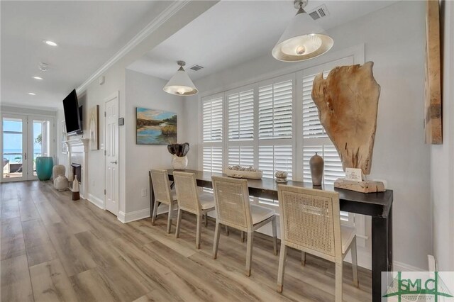 dining area featuring hardwood / wood-style floors and crown molding