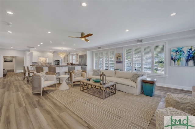 living room featuring light hardwood / wood-style flooring and ceiling fan