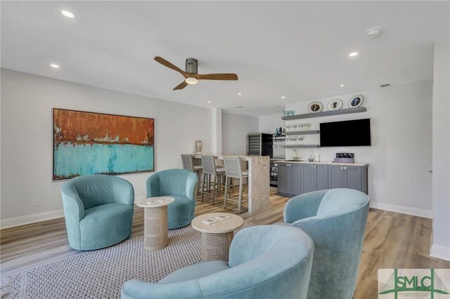 living room featuring light wood-type flooring and ceiling fan