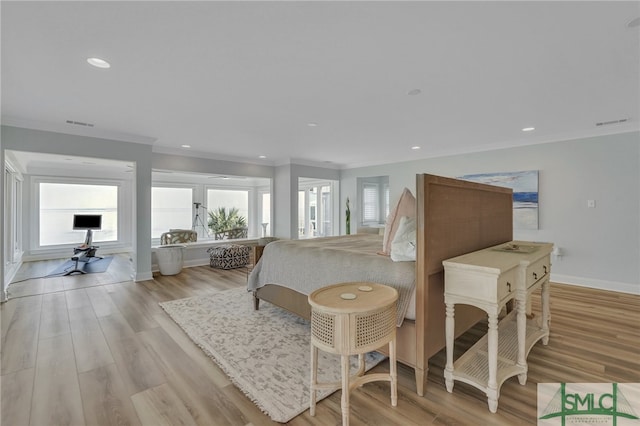 bedroom with crown molding, light hardwood / wood-style flooring, and multiple windows